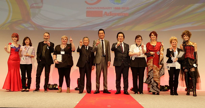 優勝したメンバーとモデル、遠藤憲一さん（中央）、根本会長（中央左）、津村社長（中央右）